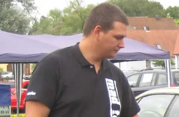 Junger Mann vor Pavalion mit bedrucktem Poloshirt