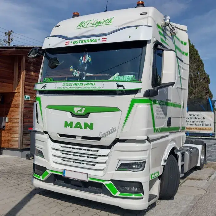 Weißer MAN LKW mit grüner Werbeaufschrift